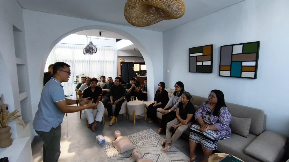 FirstMedic instructor conducting complimentary First Aid and Basic Life Support (BLS) training with Premier Hospitality staff in Bali, including CPR practice, AED demonstration, and emergency response simulation.